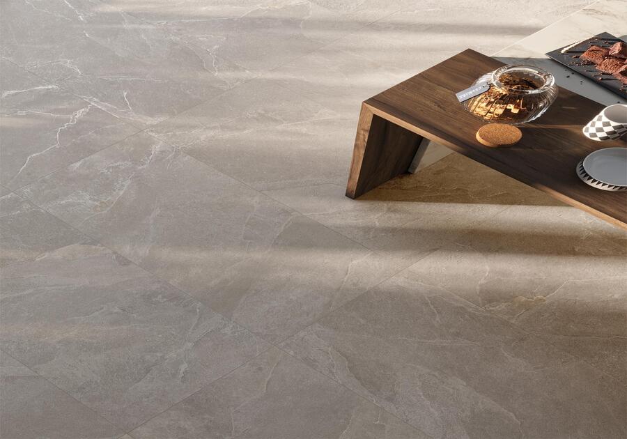 on voit le sol d'une maison carrelé en imitation ardoise, grande dalle et une table en bois